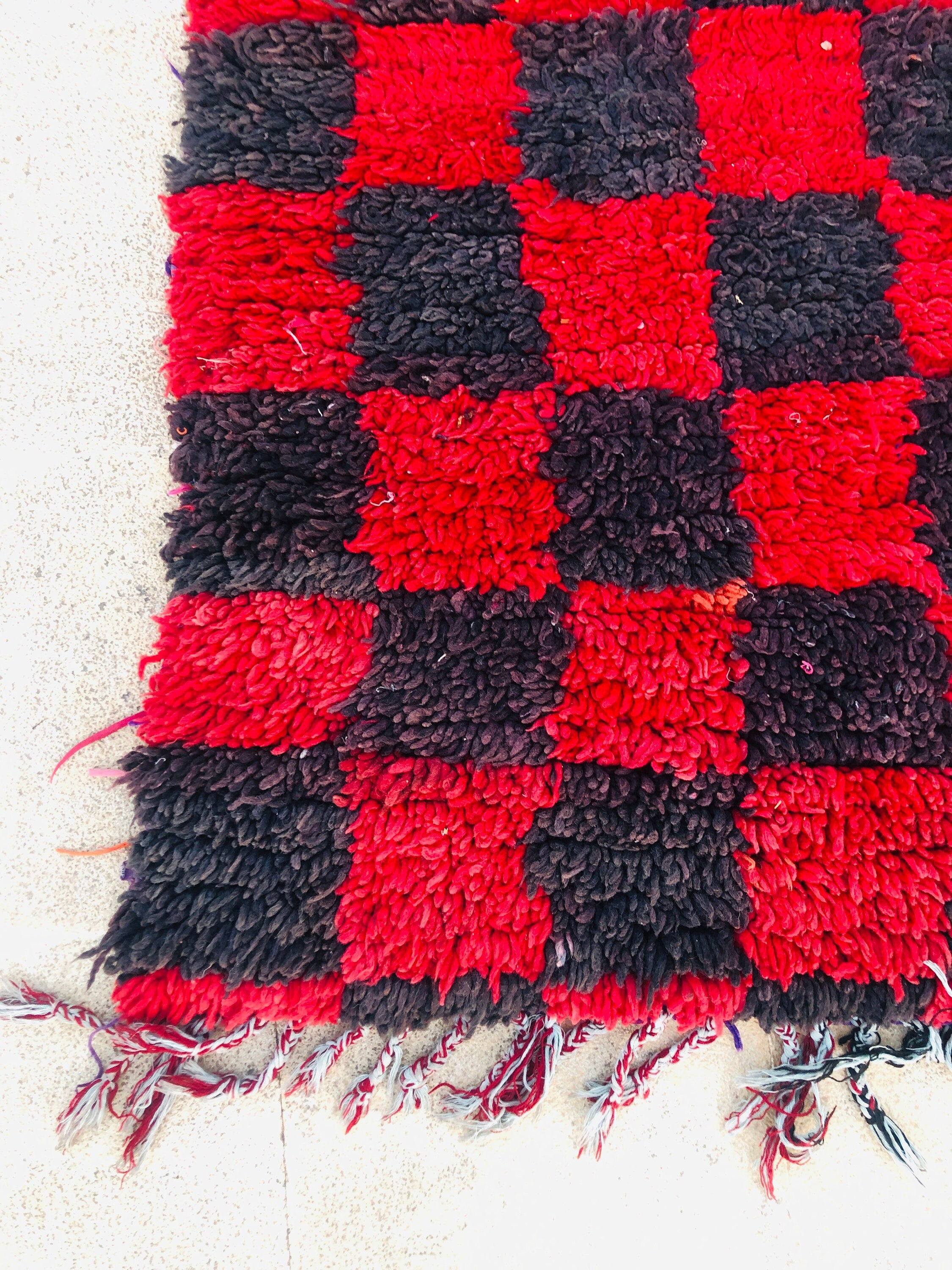 Handcrafted red and black checkered rug, perfect for bohemian home decor styling.