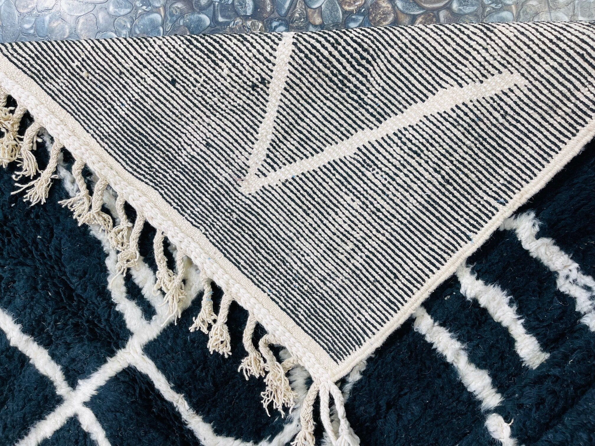 black and white patterned rug with tassels