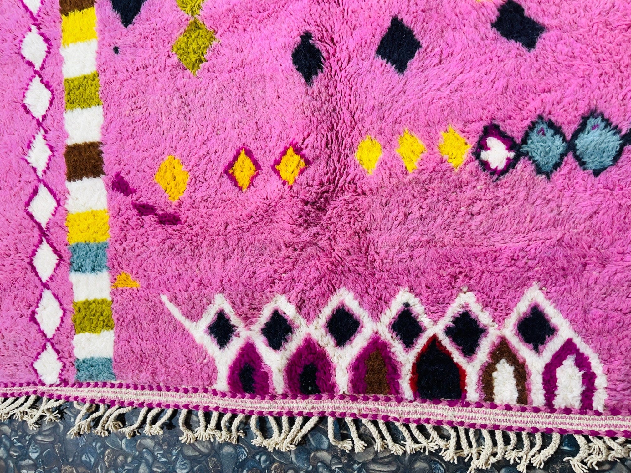 colorful pink patterned rug with decorative fringe