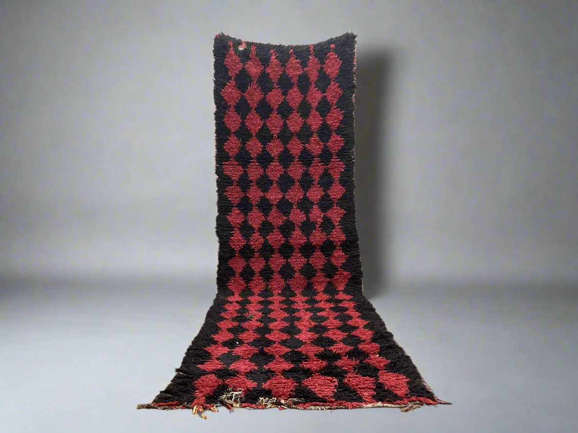 Handwoven geometric patterned rug in rich red and black colors, ideal for home decor.