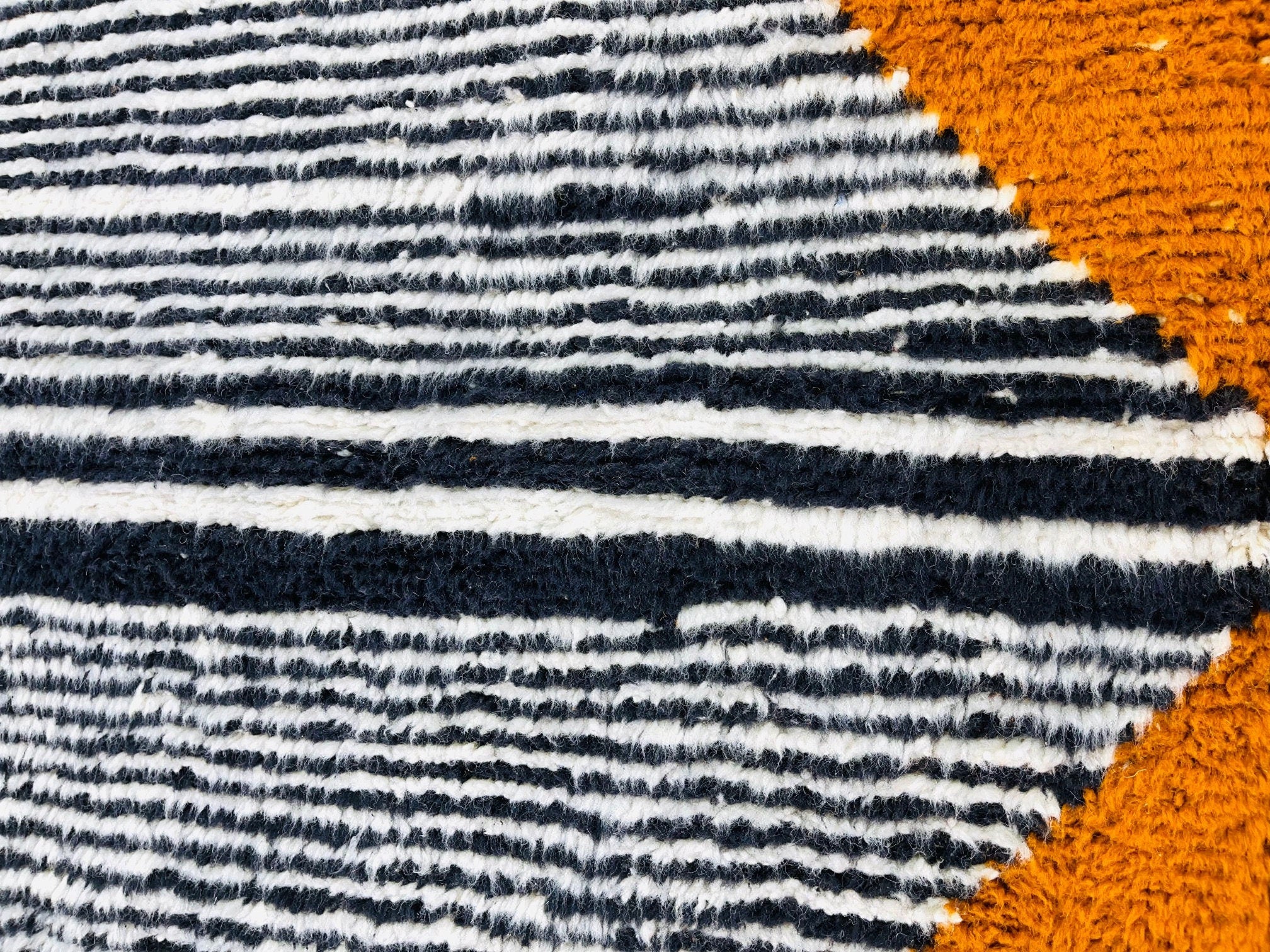 striped textured rug with vibrant orange accents