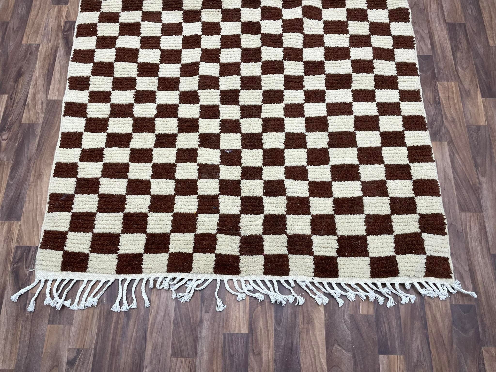 Brown and cream checkered area rug with fringe for stylish home decor.