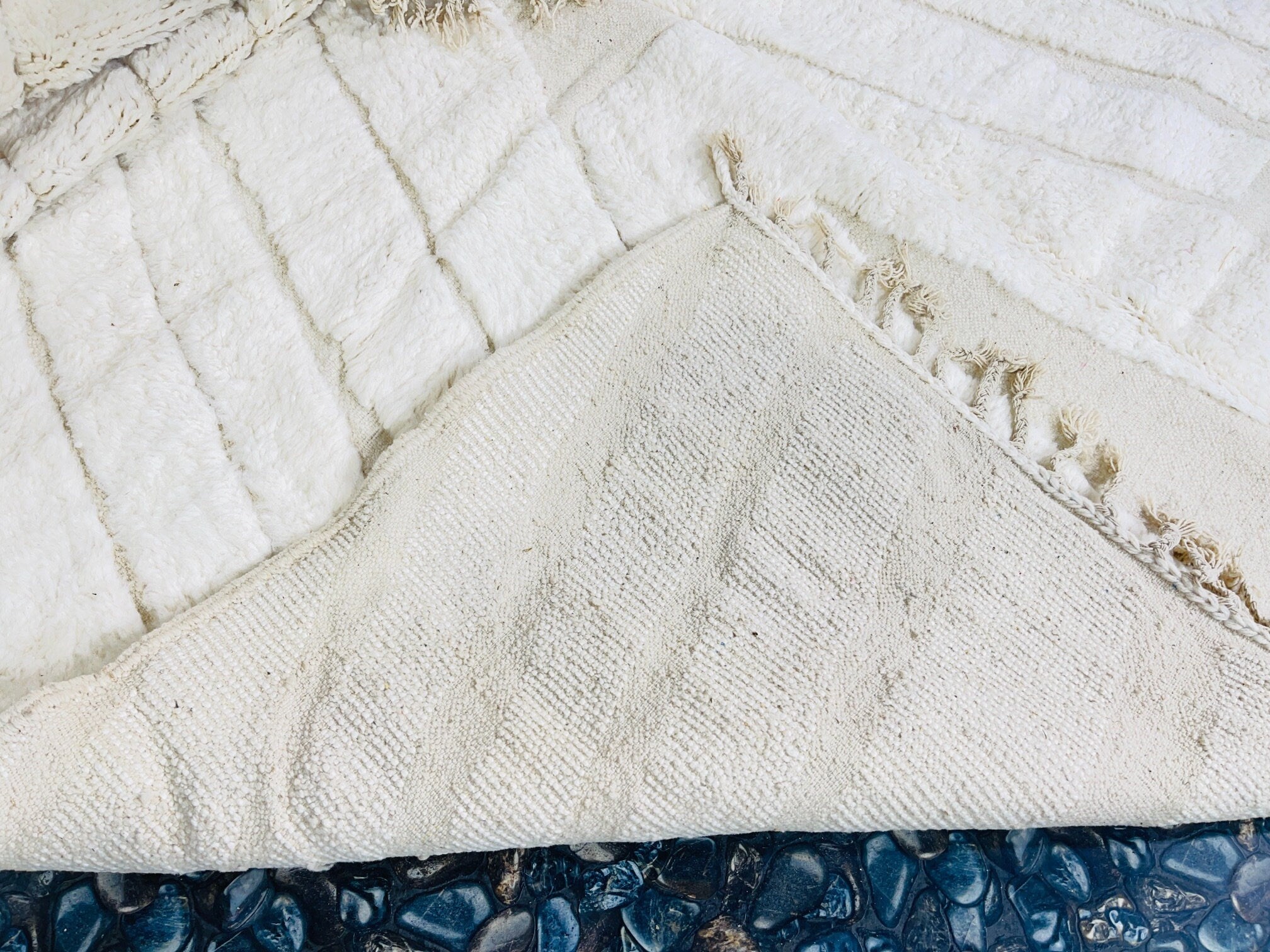 textured white blanket on dark stone surface