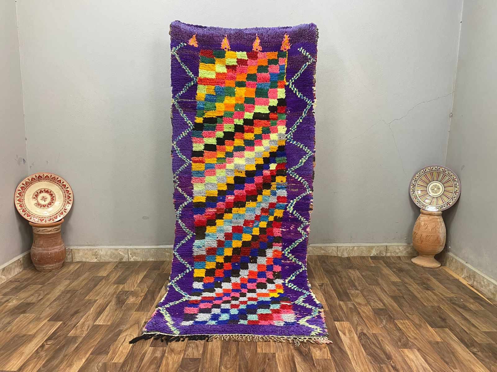 Vibrant handmade rug featuring colorful geometric patterns and purple accents for stylish decor.