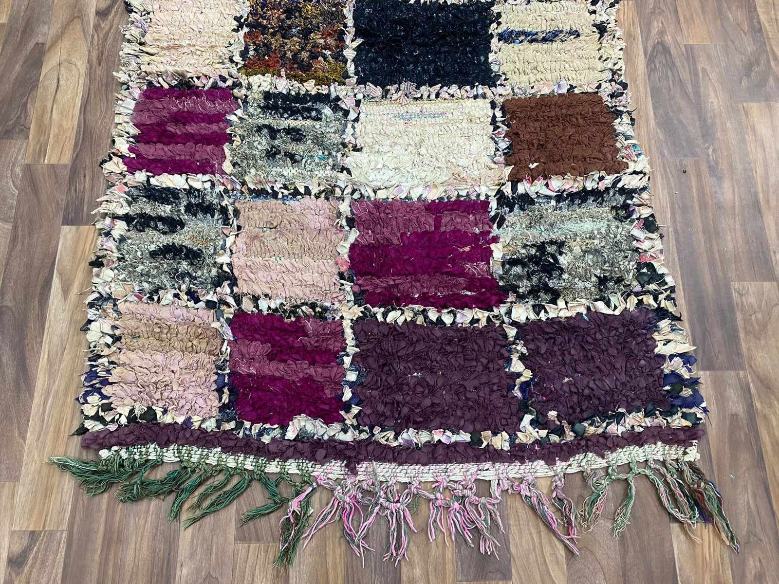 Colorful patchwork rug with unique textures and fringed edges for stylish home decor.